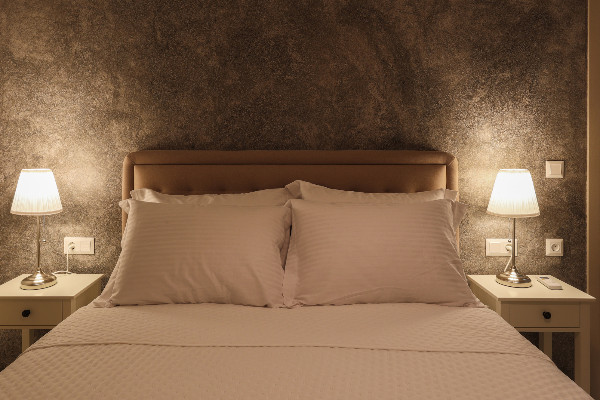 Elizabeth bedroom with a soft upholstered bed and wooden bedside table